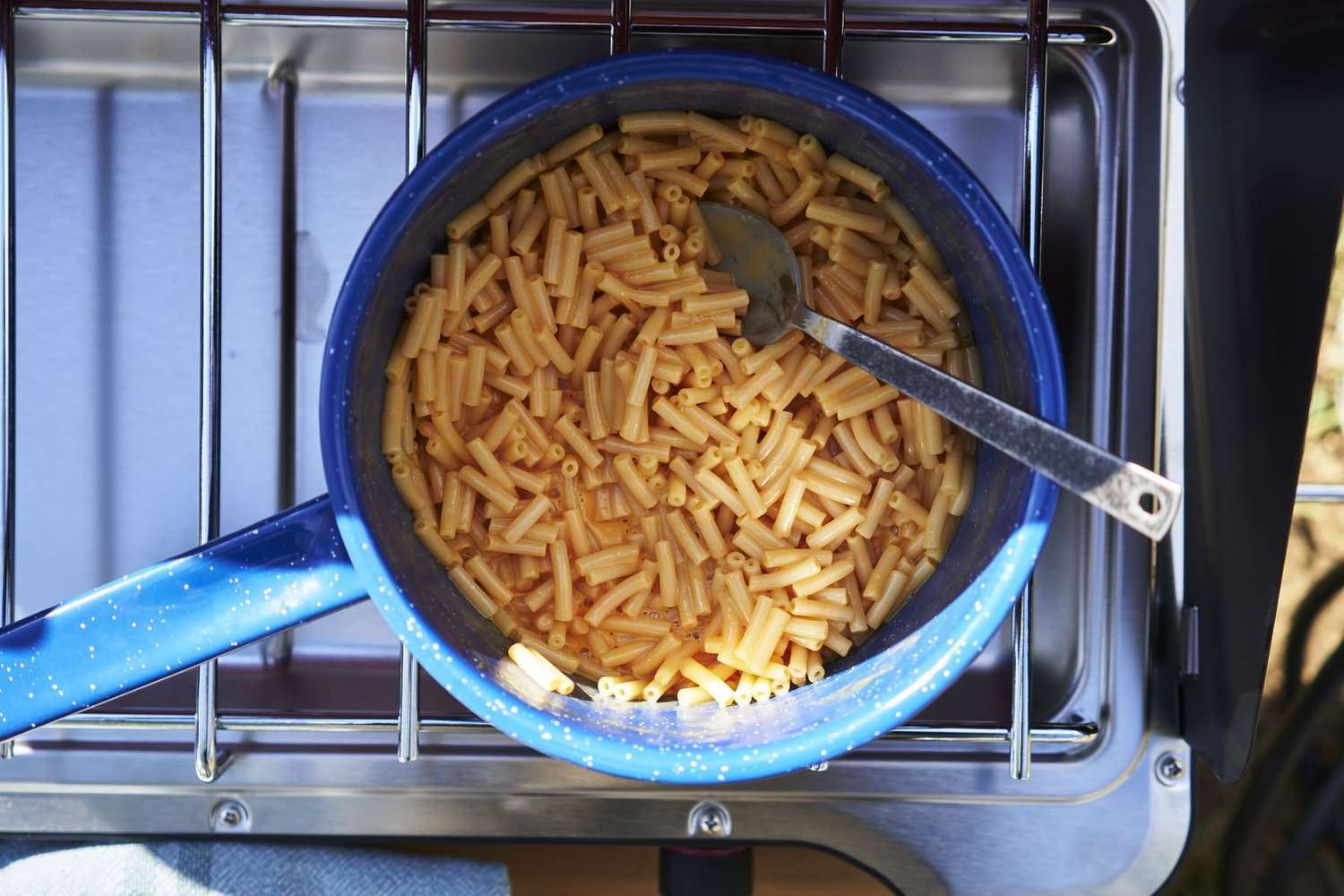 Mac and cheese in a blue pot on a camp stove
