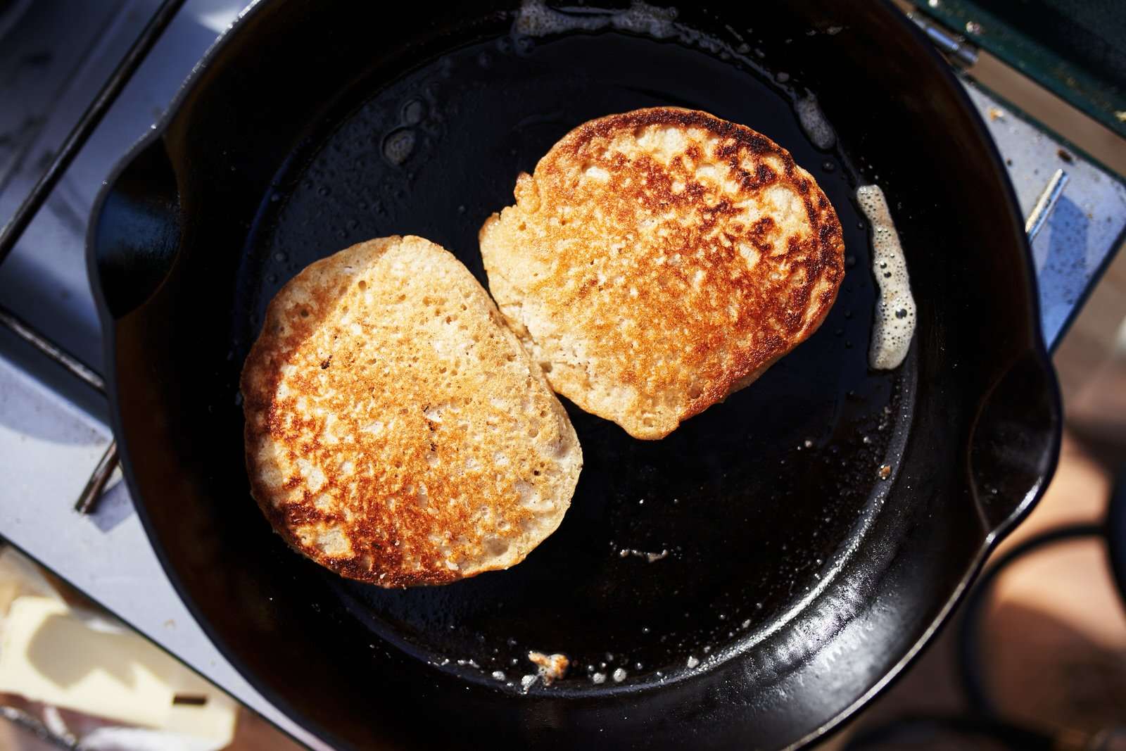 cooking pancakes in a cast iron skillet at camp