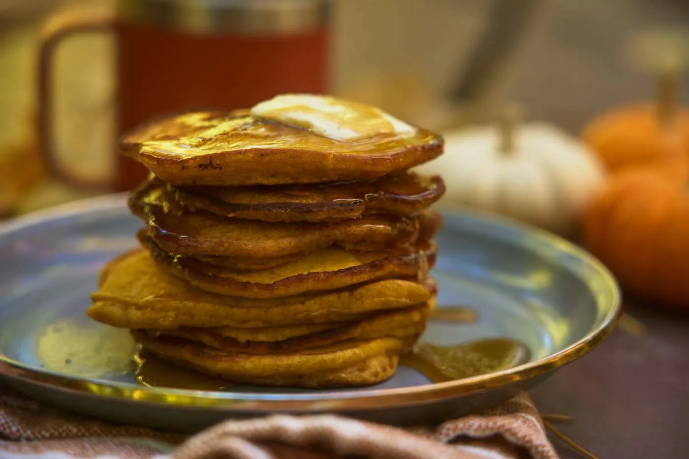 stack of pumpkin pancakes with maple syrup