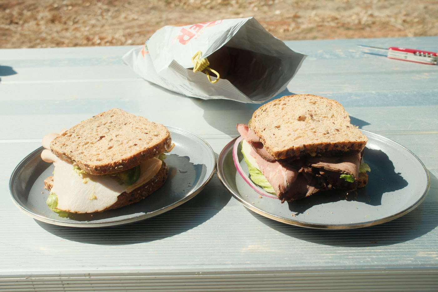 two sandwiches on a picnic table