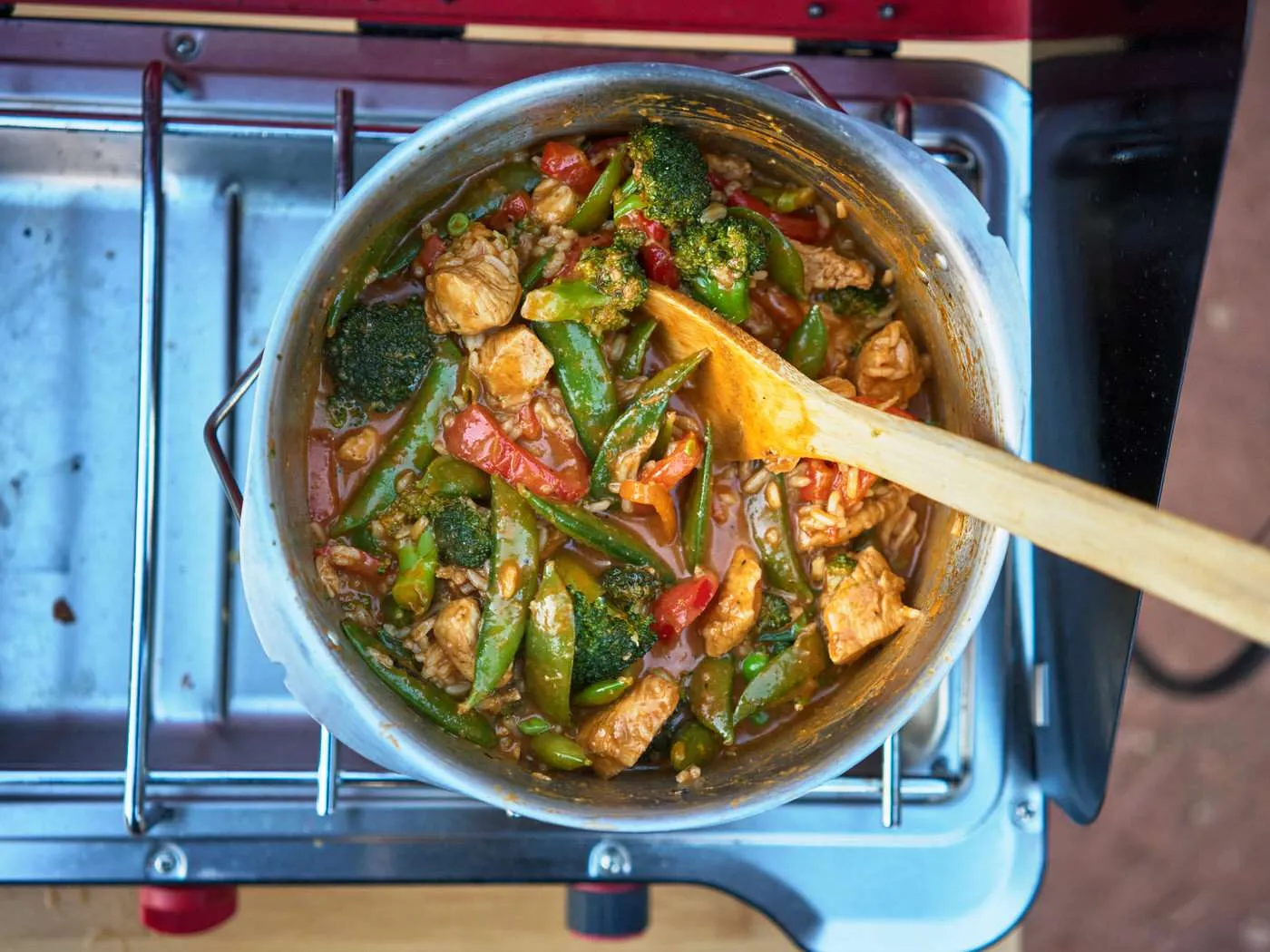 large pot of thai chicken curry with a spoon in the pot