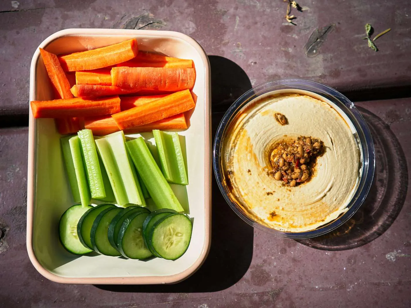tray of cucumbers, celery, and carrots with a side of hummus