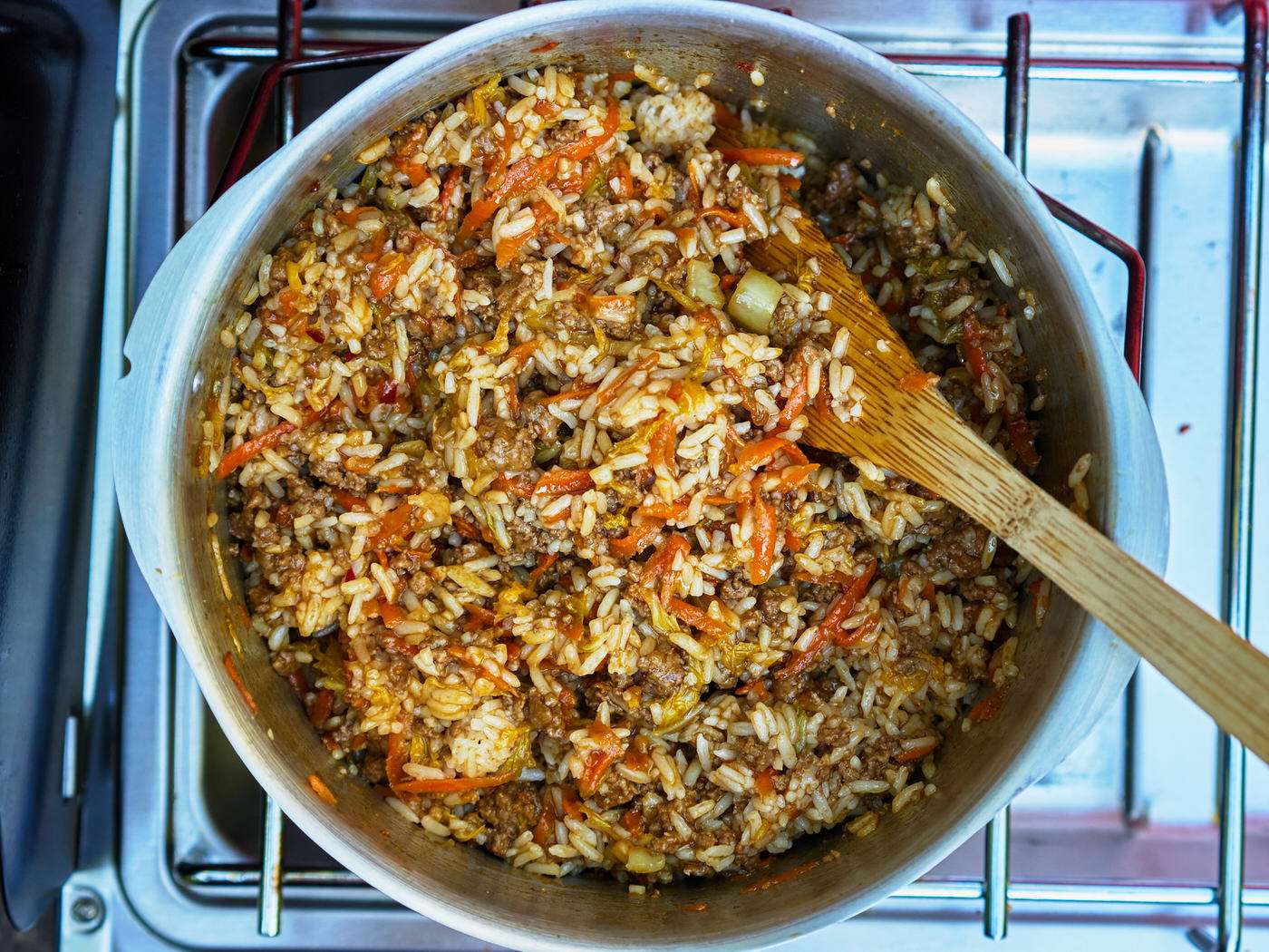 large pot with beef, rice, carrots, cabbage, and sweet ginger chili sauce