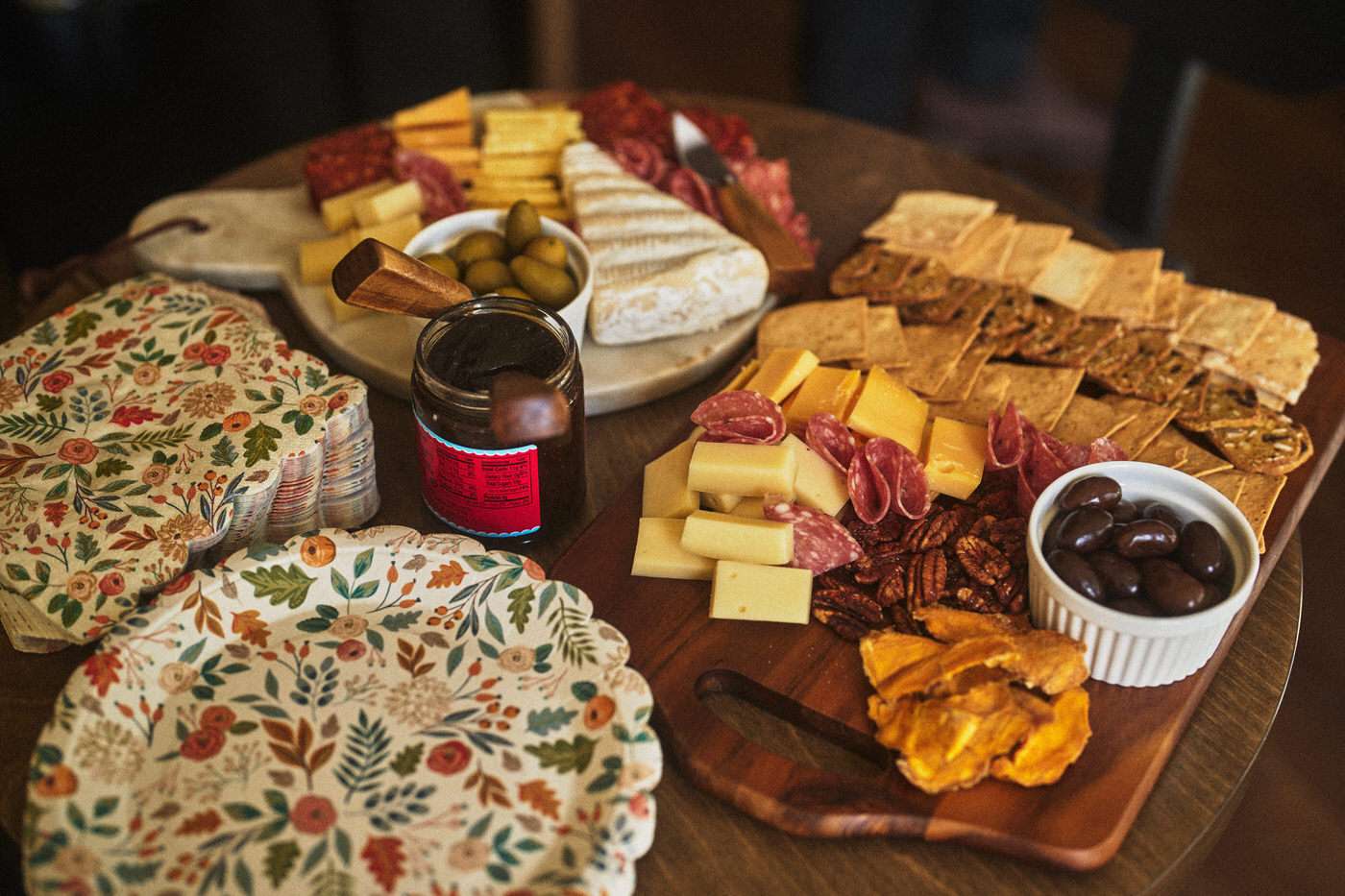 two charcuterie boards with fall themed plates and napkins 
