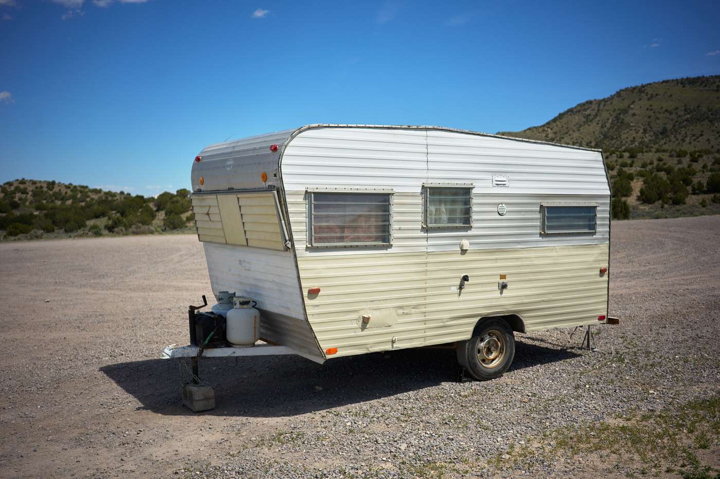 original side and front exterior of a 1960s vintage camping trailer before renovations