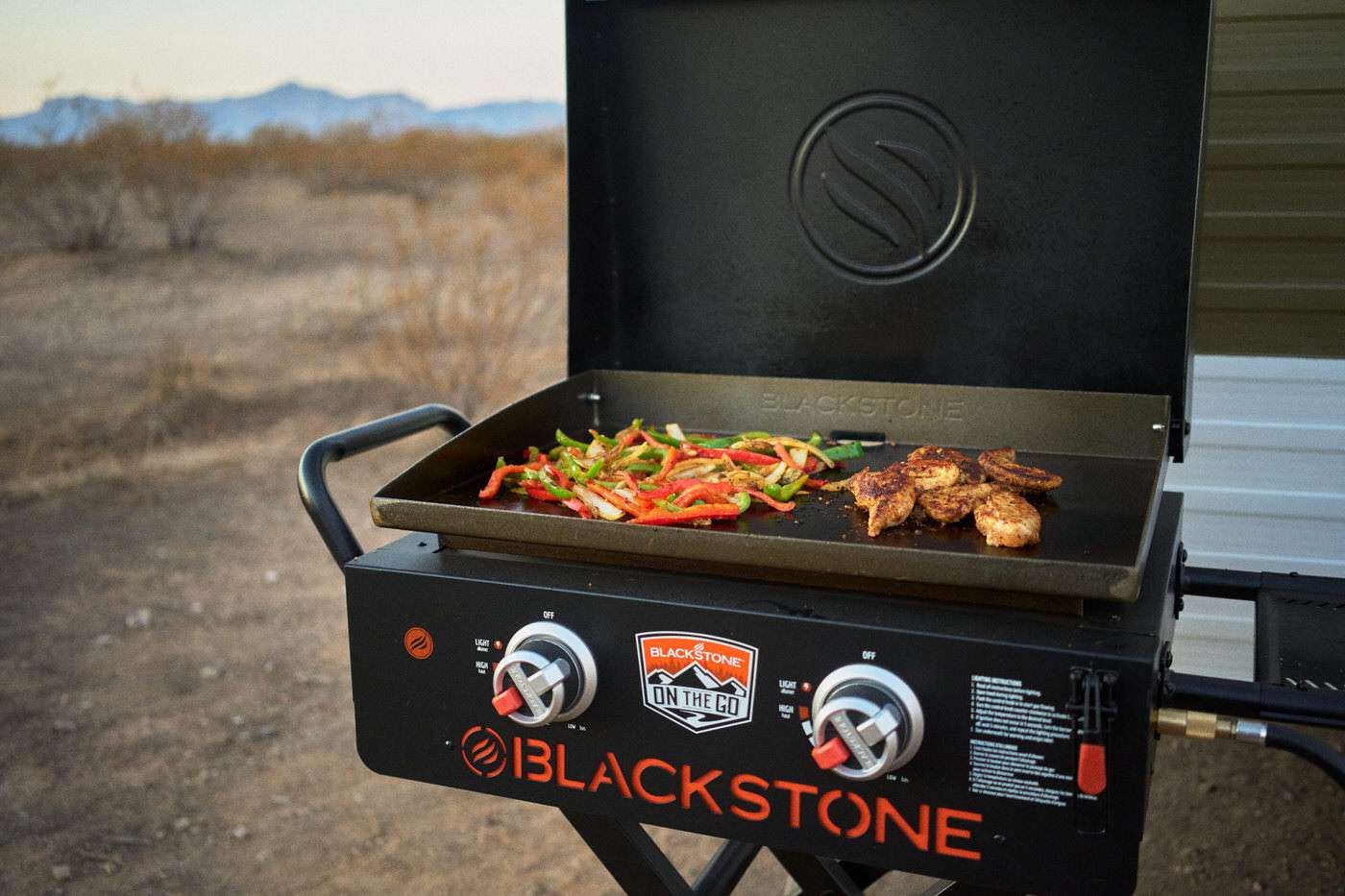peppers and chicken cooking over a blackstone griddle while camping 