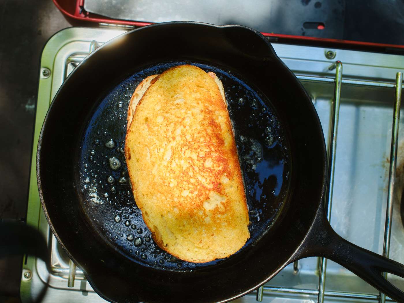 grilled cheese cooking in a cast iron skillet outside
