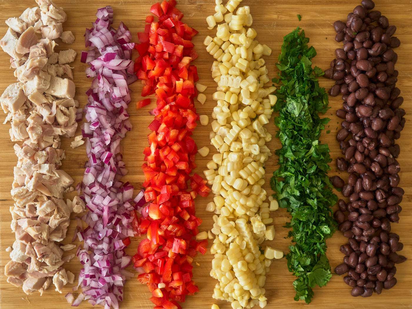chicken salad ingredients in a line on a cutting board 