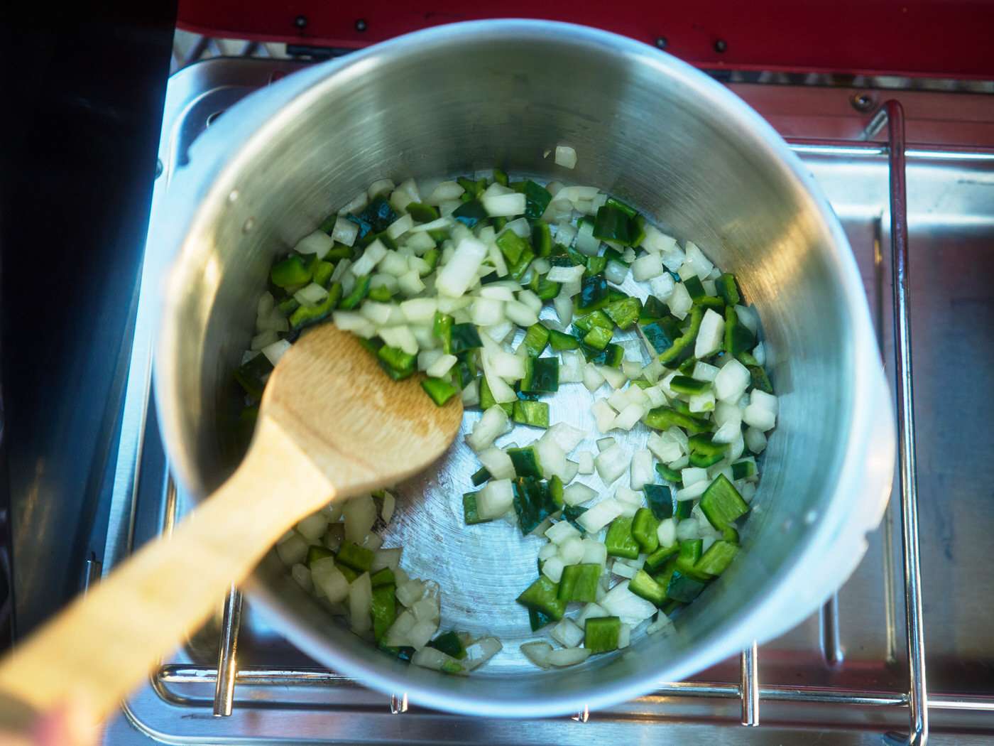 diced onions and peppers in a pot over a camp stove