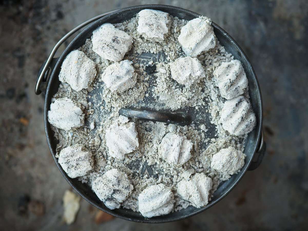 dutch oven with briquettes on top 