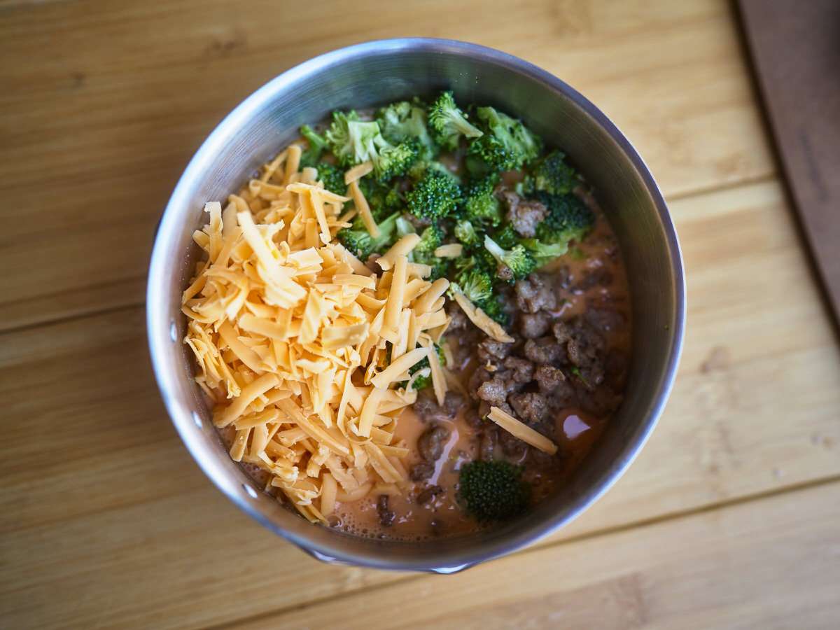 cheese, broccoli, sausage, and eggs for quiche in a pot