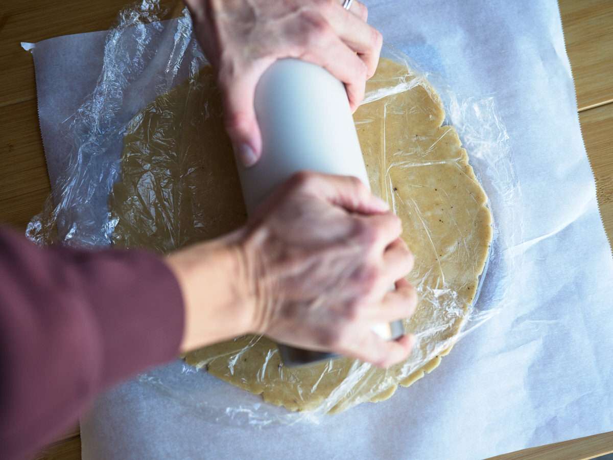 rolling out pie dough while camping for quiche recipe