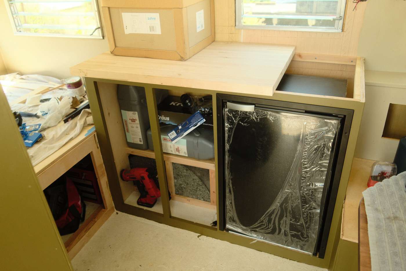 small camper fridge installed in a vintage camper kitchen