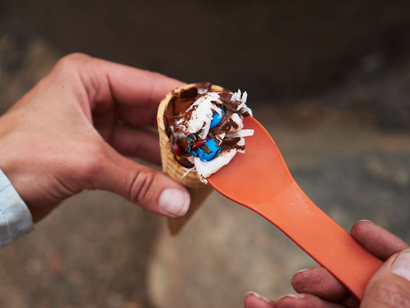 Melted chocolate, M&Ms, shredded coconut and marshmallow waffle cone smores